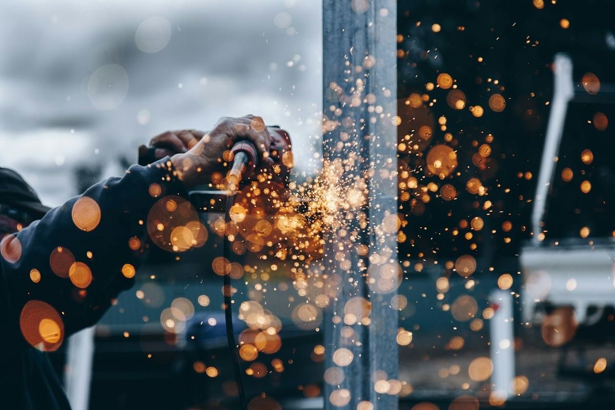 Factory worker welding metal in an industrial workshop